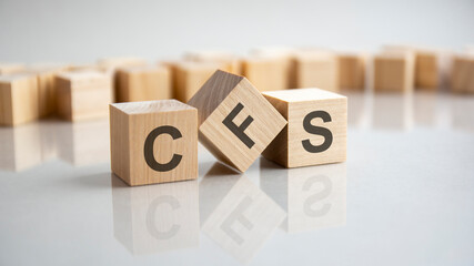 CFS word made from wooden cubes on gray background