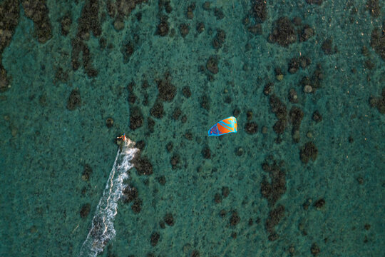 Aerial view of a person doing kite surfing along the coast at Plage de la Saline beach, Reunion.