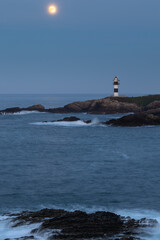 Full moon on the coast of Galicia, with lighthouse, natural rock arches, etc!