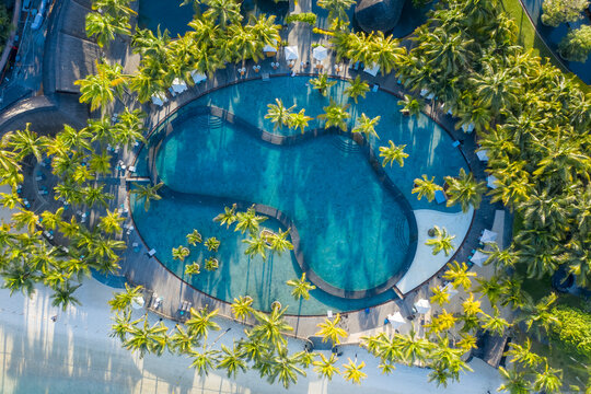 Aerial view of a beautiful swimming pool with palm trees in a luxury resort, Trou aux Biches, Mauritius.