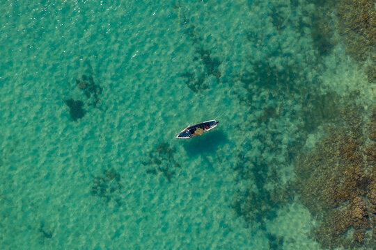 Aerial view of a small fishing boat sailing near l'Ilot Bernache, a small island along the coast near the reef, Mauritius.