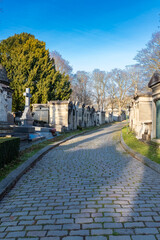 Paris, the Pere-Lachaise cemetery, cobbled alley with graves in winter
