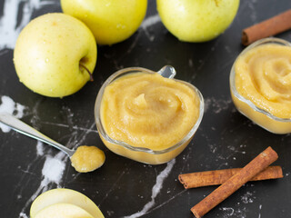 Homemade applesauce (apple puree or mousse) in small glass bowls with organic golden delicious...