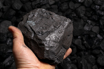 a lump of hard coal held in hand
