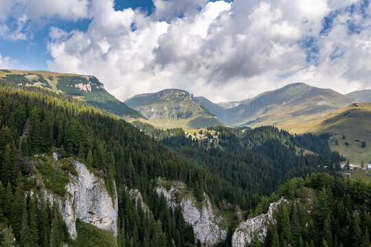 Aerial view of a mountain range during a cloudy day at Parcul Natural Bucegi, a National Park near Moroeni, Romania.