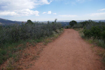 Dry gravel hiking path with hiking person in far distance