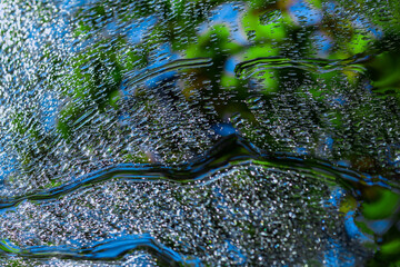 Round waves from a stream. Background with water. A sample with colorful lines, shapes. Vibrant...