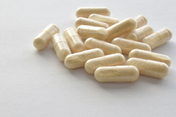 Collagen powder supplement capsules on white background.	

