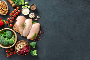 Set for cooking healthy food. Green vegetables, nuts, beans, seeds and chicken breast on dark background with copy space, top view. Clean eating or diet concept © kucherav