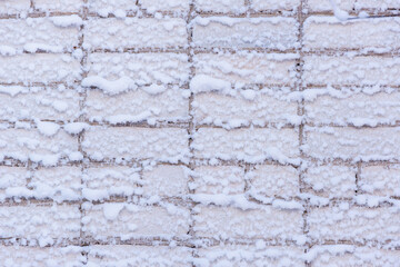 White brick wall in the snow. Frost on bricks in winter.