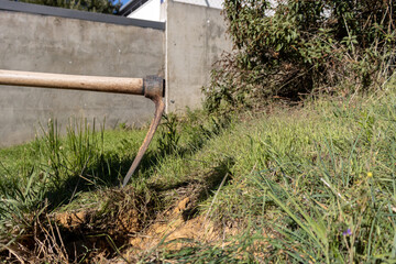 detail shot of a hoe digging the soil of a garden for planting