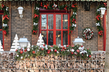 Fototapeta na wymiar Seasonal Christmas decoration at front of a cafe at european city street. Festive street decor in winter holidays. Selective focus.