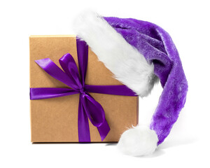 Isolated Christmas gift with a bow with a purple Santa hat on white background. The trendy 2022 color Very Peri.
