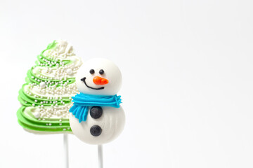 Confectionery sugar tree and snowman for decorating cakes on a white background with copy space.