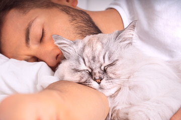 Man sleeping with cat. Lovely cat and owner. Love and trust between owner and cat. 