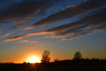 Obraz na płótnie Canvas Dramatic Sunset Over a Field