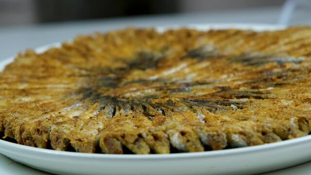 Turkish fried anchovy (hamsi)  served on with white plate in black