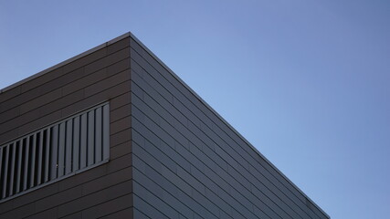 Fototapeta na wymiar corner of modern facade against sky