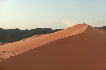 Sahara desert's dunes at sundown, Man running alone in the hot dunes enjoying a great feeling of freedom