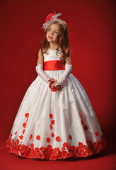 Little girl in a white dress on a red background..