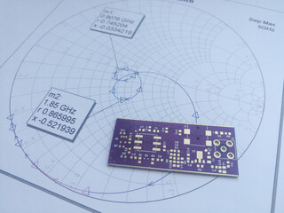 RF PCB in front of Smith chart for design and development - obrazy, fototapety, plakaty