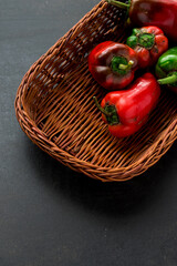 Fototapeta na wymiar Some fresh red chili pepper in a basket on a black wooden table 
