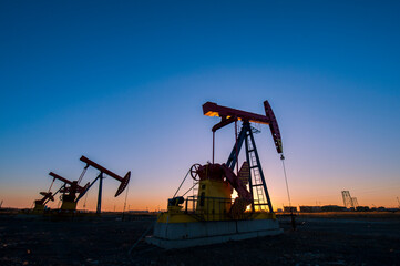 Oil pumps are running in the sunset at the oil field. On the Bohai coast of China.