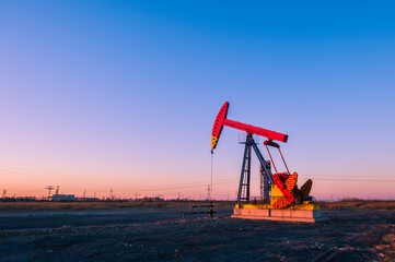 Oil pumps are running in the sunset at the oil field. On the Bohai coast of China.
