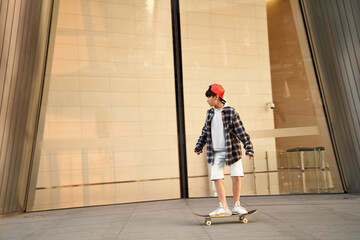 teenage asian boy skateboarding outdoors © imtmphoto