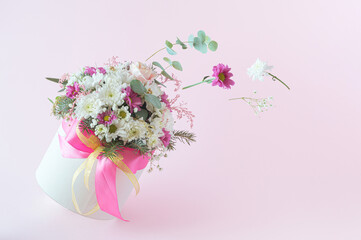 Gift box with flowers on a pink background. Flying flowers from the box. Valentines day aesthetic nature concept.