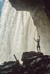 Fitness guy standing in front of a waterfall in Chapada das Mesas National Park, in Brazil