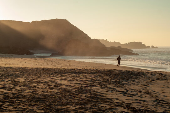 Hombre adulto blanco corriendo al amanecer en Playa Mermejita, Mazunte, Oaxaca. 