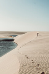 Lençóis Maranhenses - Lonely guy walking away leaving footsteps on the dunes of this brazilian national park