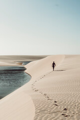 Lençóis Maranhenses - Lonely guy walking away leaving footsteps on the dunes of this brazilian...
