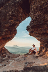 Guy seated in Portal da Chapada viewpoint in Chapada das Mesas National Park in Brazil