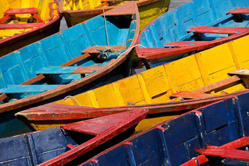Fototapeta na wymiar Colorful wood tourist boats on Begnas Tal (Begnas Lake) near Pokhara, Nepal