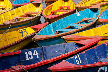 Fototapeta na wymiar Colorful wood tourist boats on Begnas Tal (Begnas Lake) near Pokhara, Nepal