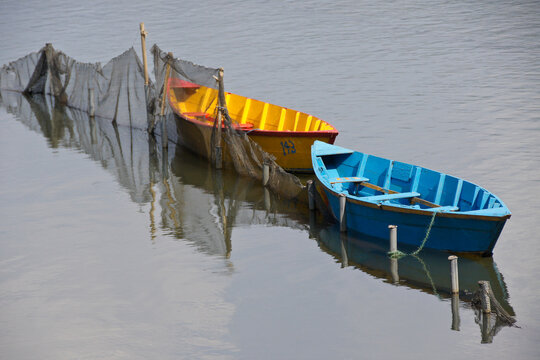 Fish net and colorful wood tourist boats on Begnas Tal (Begnas Lake) near Pokhara, Nepal