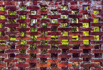 Red brick fence around garden, with an open lattice design.