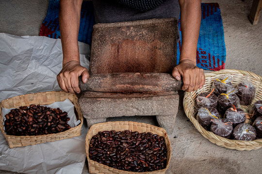 Close-up shot of person grinding beans using primitive equipment