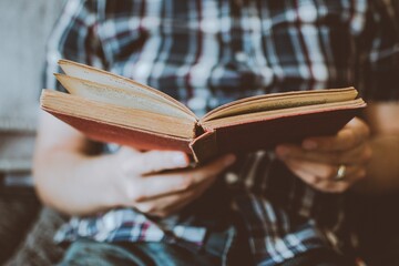 Cropped image of man sitting and reading a book