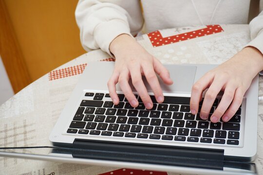 Cropped image of hands using laptop