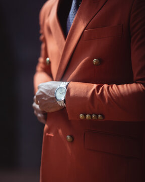 Cropped image of man in red suit wearing analog watch