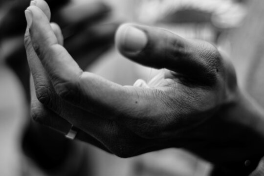 Grayscale photo of an open hand begging