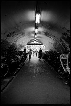 Fototapeta Grayscale photo of people walking through tunnel