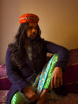 Indian man with long hair sitting on floor indoor