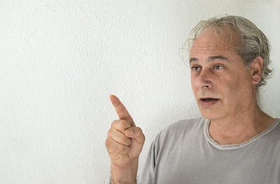 Man in gray shirt pointing with his finger