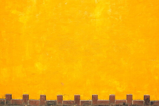 Pared amarilla con ladrillos abajo