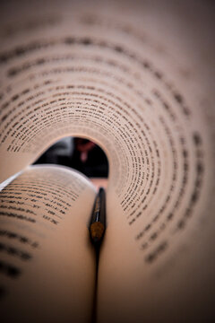 Pen in a book with turned page like tunnel