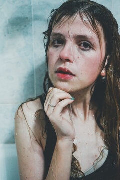 Portrait of wet woman against tile wall